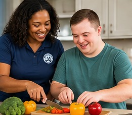 Support worker helping an adult practice meal preparation